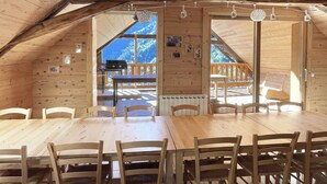 Eine Holzhütte mit Essbereich, Holzwänden und Blick ins Freie.