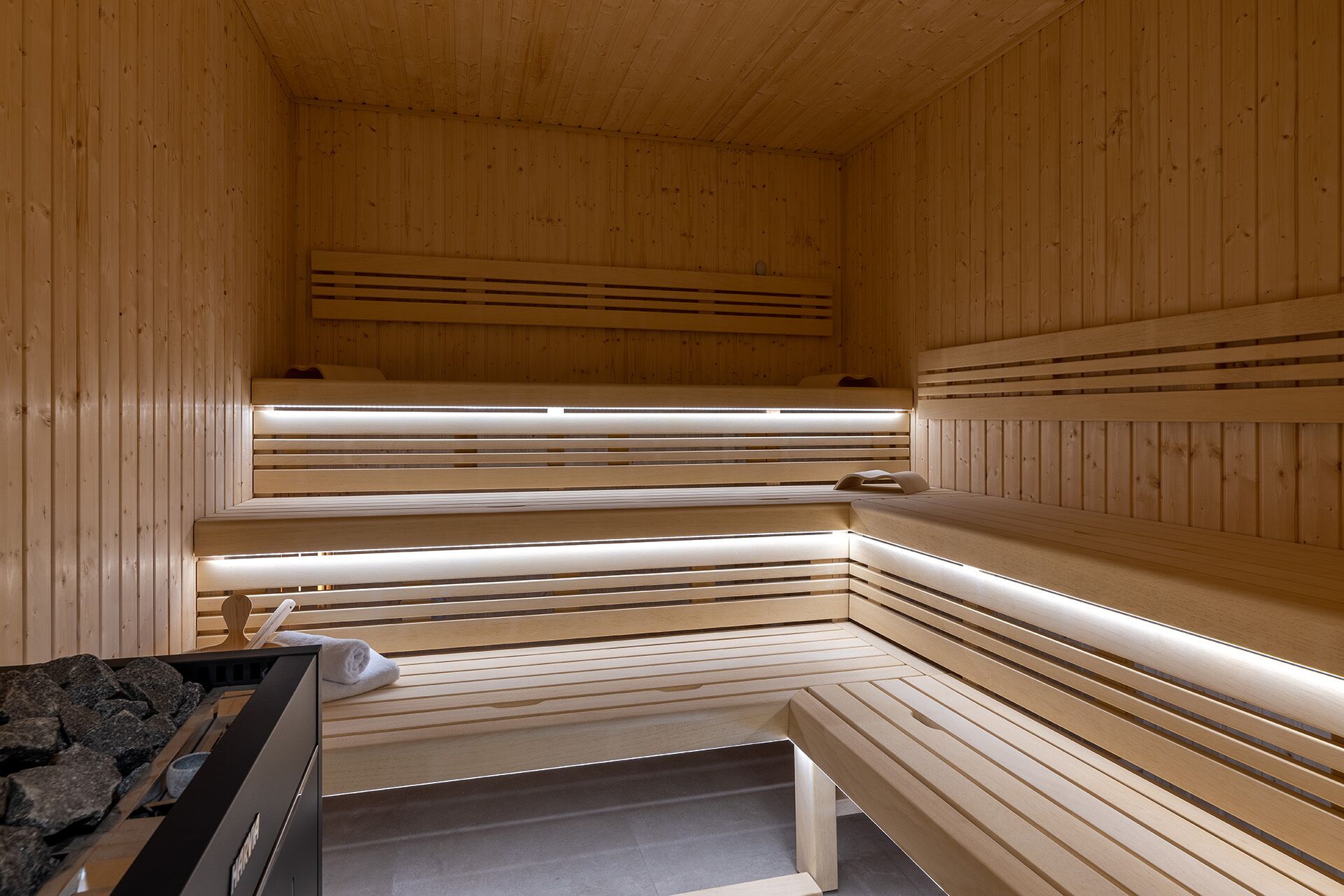 A sauna with wooden benches and a bench with a towel.