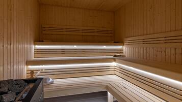 A sauna with wooden benches and a bench with a towel.
