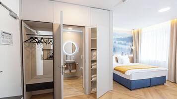 Ein Hotelzimmer mit Bett, Badezimmer und Schrank mit Spiegel.