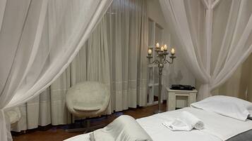 Relax in a classic room with a large bed, a comfortable chair, and a cozy reading nook.