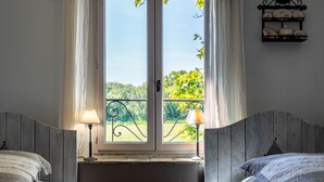 A bedroom with a large window, two bedside lamps, and a wall-mounted shelf with decorative items. - NICE PROVENCALE HOUSE 4 pers country garden swimming pool SPA playground (Grans)