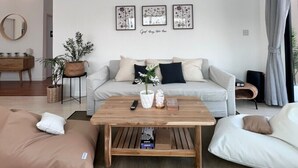 A modern living room with a sofa set, a coffee table, and decorative wall art.