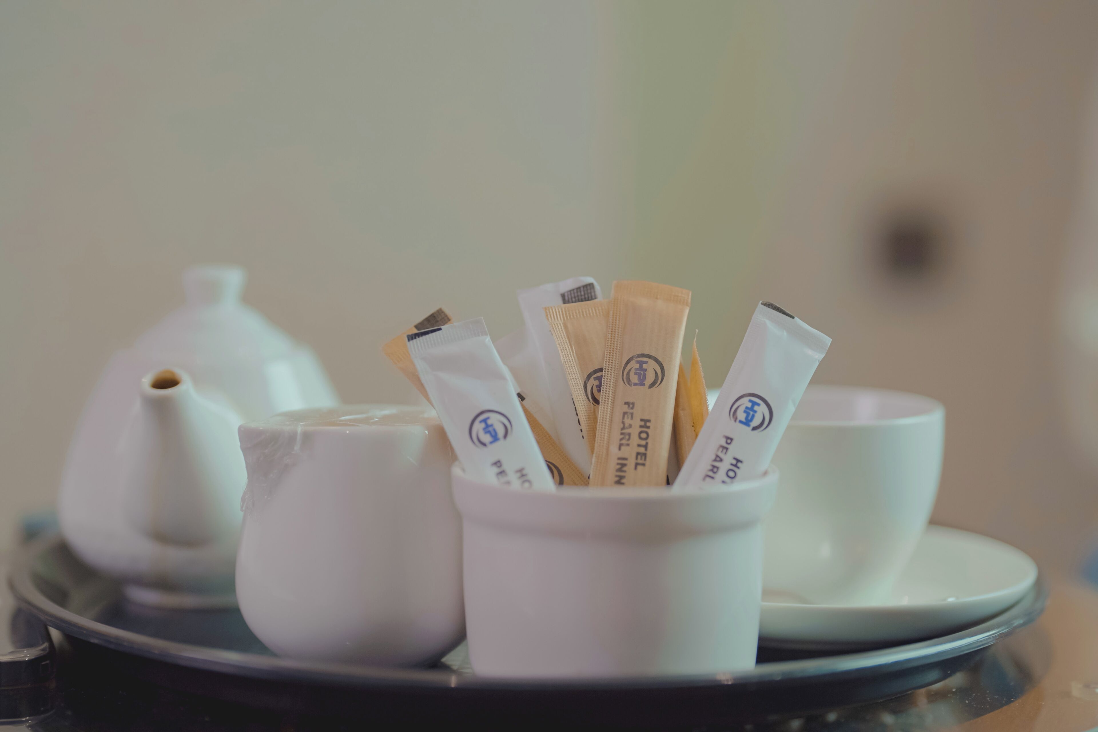 A tray with a teapot, a cup, and a cup of tea bags.