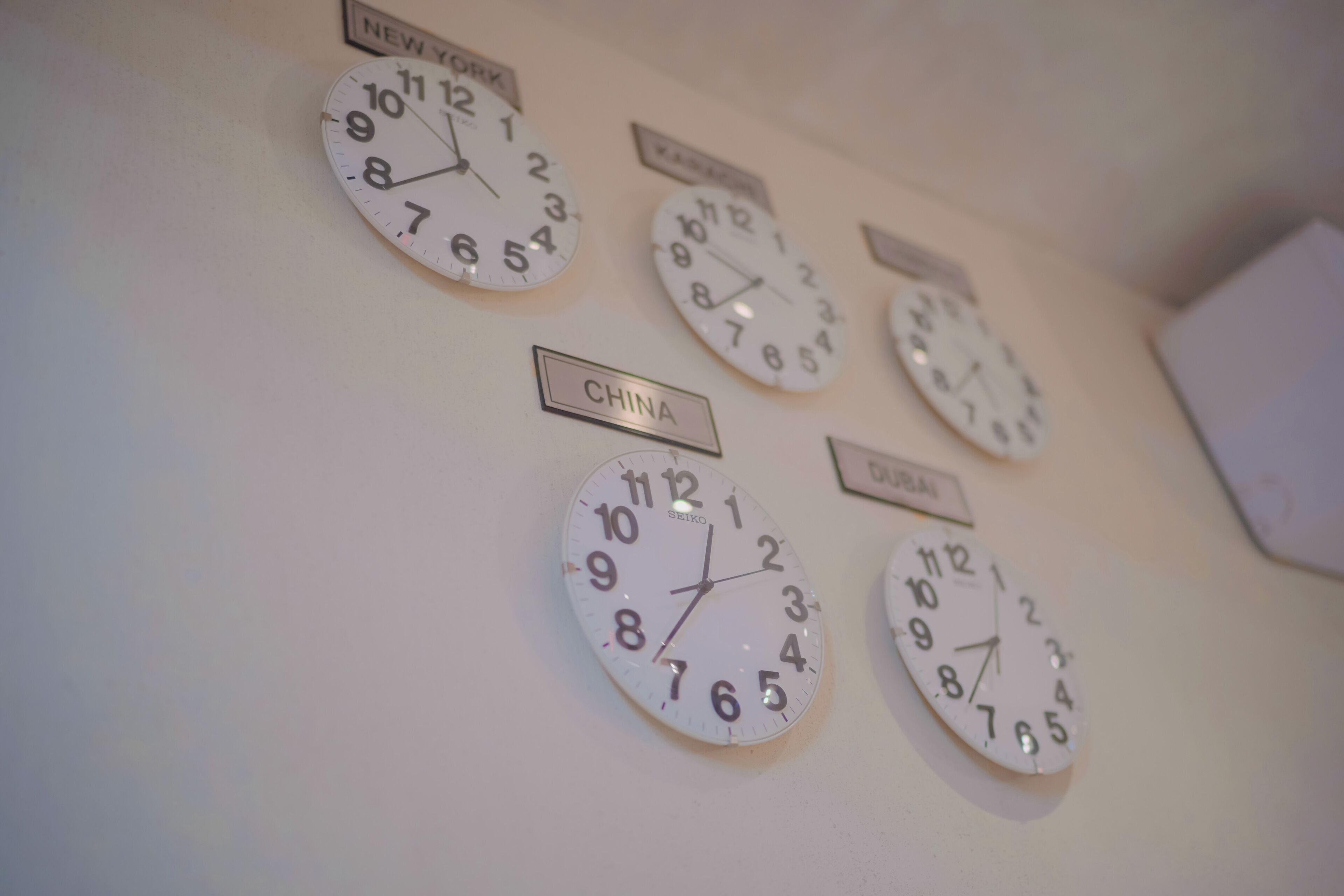 A wall with multiple clocks, each labeled with a different country name.