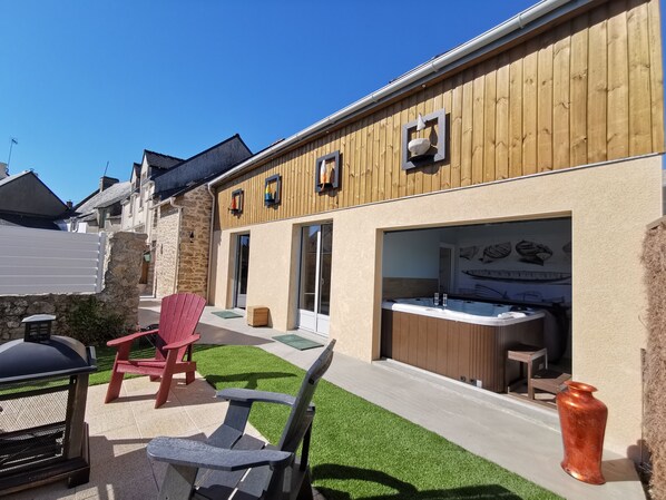 A wooden building with a patio area, outdoor seating, and a hot tub. - Gite de la Baleine with Jacuzzi in La Turballe (La Turballe)