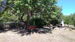 A picnic area with a bench, picnic tables, and a barbecue grill. - Letizia apartment in farmhouse in the countryside (Bivio Ravi)