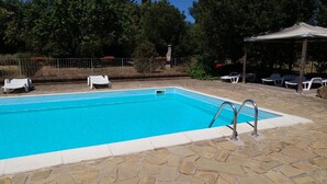 A rectangular swimming pool with a stone border, surrounded by a stone patio. - Letizia apartment in farmhouse in the countryside (Bivio Ravi)