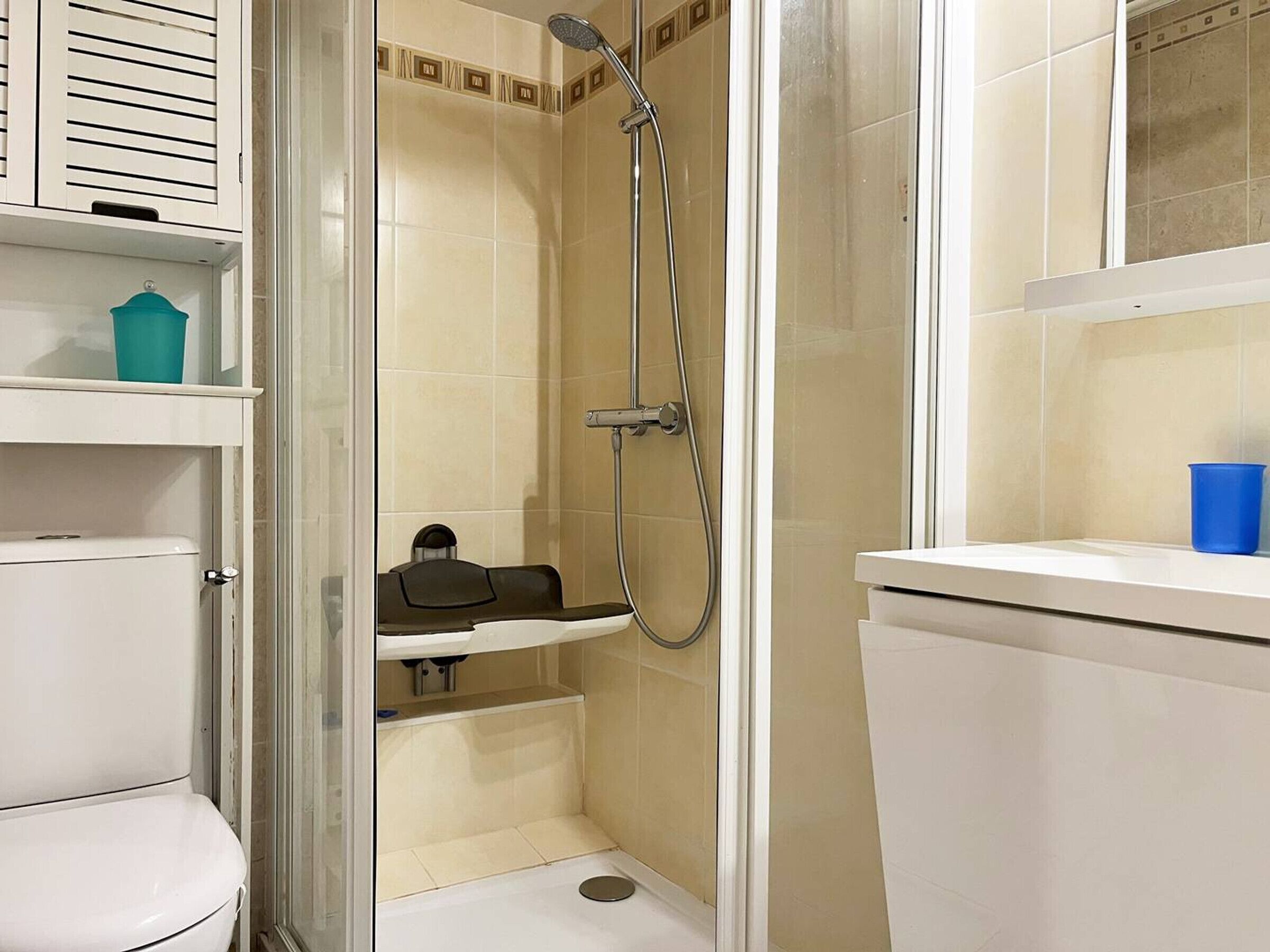 A small bathroom with a toilet, a sink, and a shower stall.