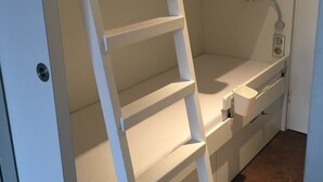 A narrow, white, wall-mounted shelf unit with multiple compartments, likely for storage. - Cozy Studio for 4 in Heart of Alpe d'Huez, South-Facing Terrace, Pet-Friendly (Huez)