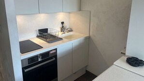 A compact kitchen with a sink, dishwasher, and a dish rack. - Cozy Studio for 4 in Heart of Alpe d'Huez, South-Facing Terrace, Pet-Friendly (Huez)