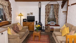 A cozy living room with a fireplace, a television, and comfortable seating.
