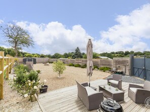 A deck with outdoor furniture and a barbecue grill.