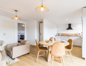 A modern, well-lit living room with a dining area, a kitchen, and a bedroom. - Cozy house with terrace in Tourlaville (Cherbourg-en-Cotentin-Tourlaville)