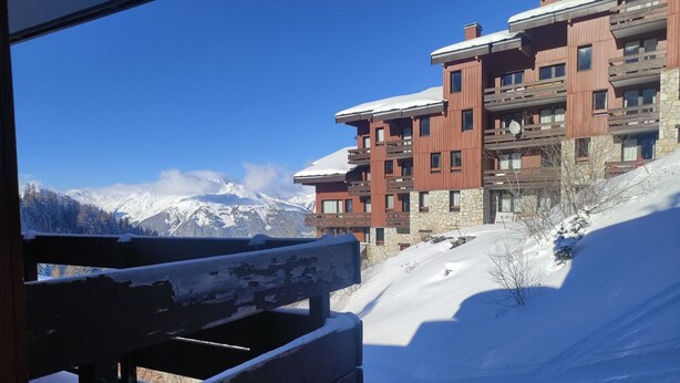 A snow-covered mountain view with a wooden bench in the foreground. - Cozy apartment with balcony, pool and optional parking in Plagne 1800 (La Plagne 1800)