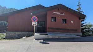 A red building with a sign reading 'Digitale' and a no parking sign. - Cozy apartment with balcony, pool and optional parking in Plagne 1800 (La Plagne 1800)