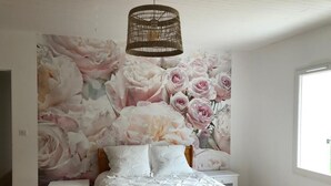 A bedroom with a large floral mural on the wall, a bed with white bedding, a small bedside table, and a hanging light fixture. - THE SIGNORET HOUSE IN THE COUNTRYSIDE NEAR BORDEAUX (Baron)