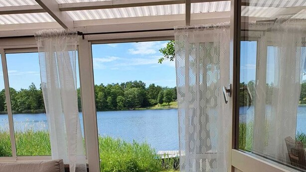 Una habitación con vistas a un lago, un sofá y una mesa de madera.