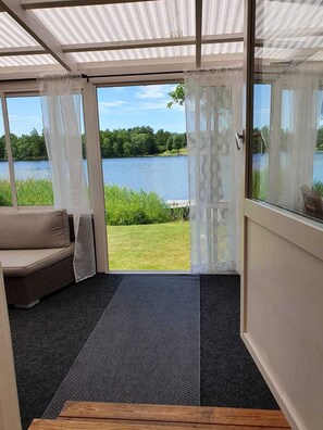 Ein Zimmer mit Seeblick, einer Couch und einem Holztisch.
