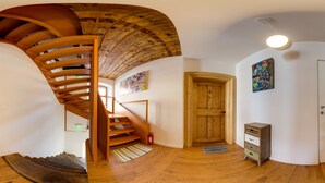 A spiral staircase with wooden railings and a wooden ceiling. -  Rossmarkt Haus (Brasov)