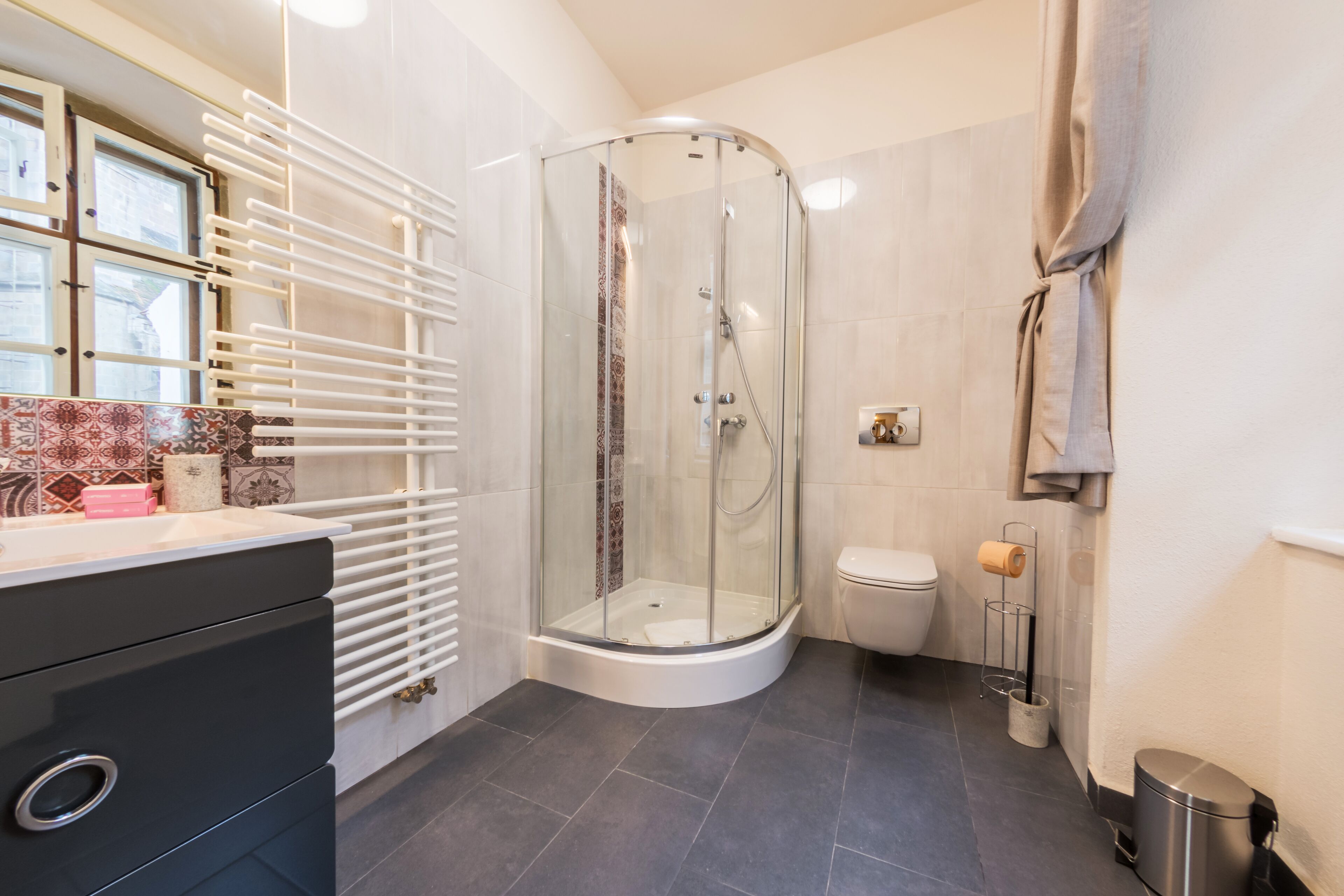Ein modernes Badezimmer mit einer Duschkabine, einer Toilette und einem Waschbecken mit Handtuchhalter.