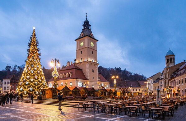 Una plaza con un gran árbol de Navidad y una torre del reloj.