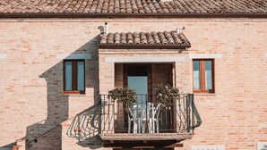Un edificio de ladrillo con un balcón, una ventana y una puerta.