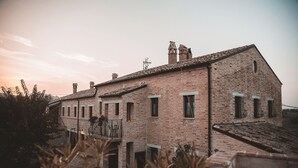 Un edificio de ladrillo tradicional con varias chimeneas y un balcón.