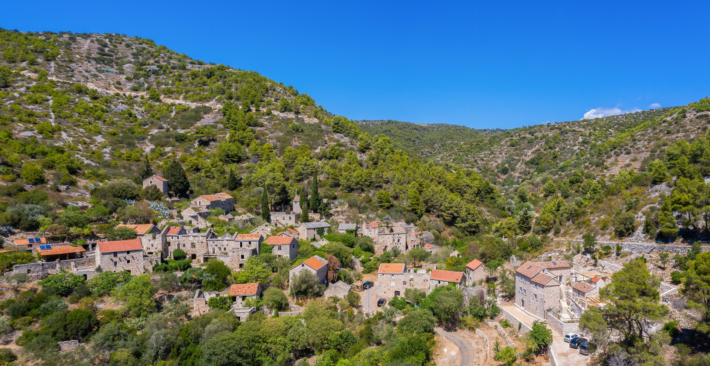 A village with stone buildings and a winding road.