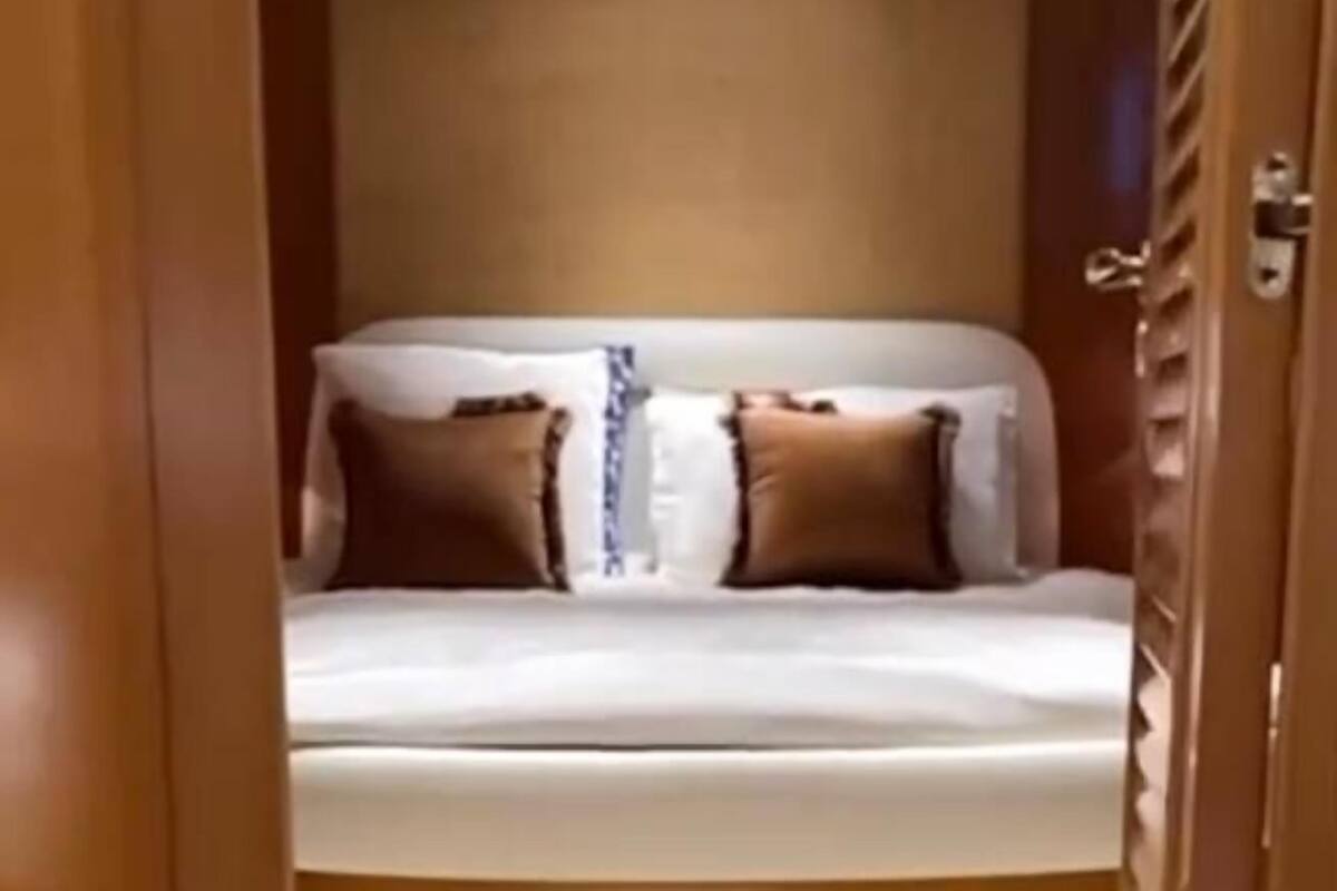 Un lit superposé avec deux oreillers, une bande lumineuse rouge et une porte en bois.