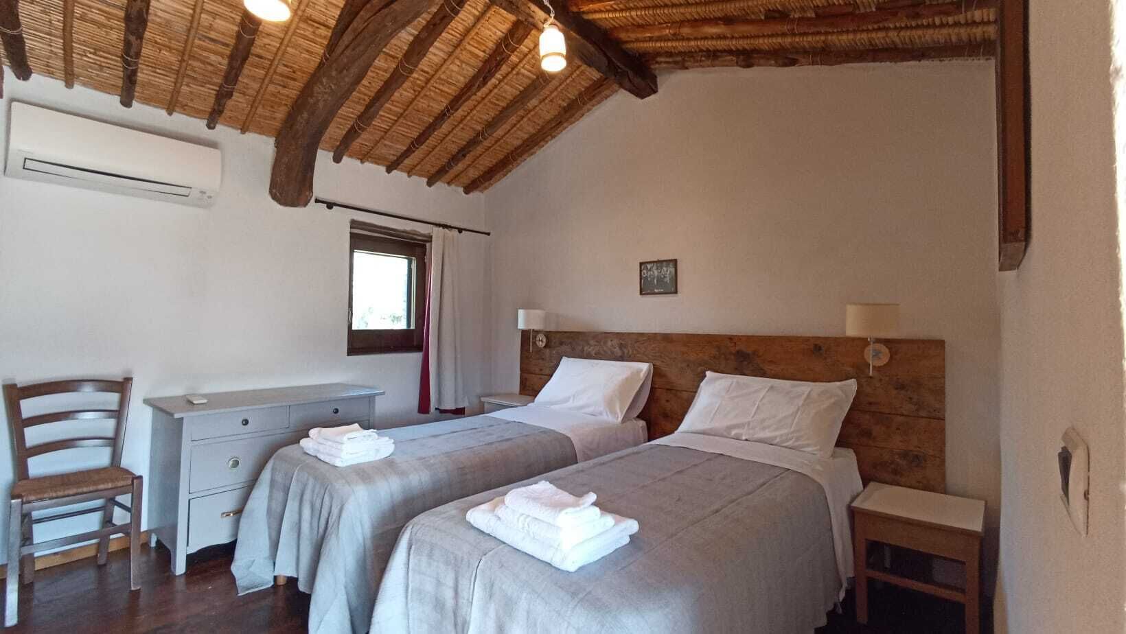 Een kamer met twee bedden, een bureau en een stoel.