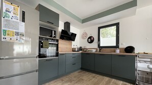 Une cuisine moderne avec des meubles de couleur grise, un four encastré et une fenêtre.
