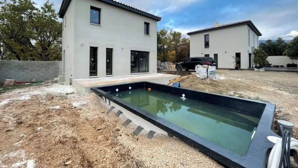 Une maison moderne à deux étages avec une piscine dans le jardin.