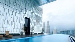 Ein moderner Infinity-Pool mit Blick auf die Petronas Towers.