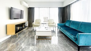 Ein modernes Wohnzimmer mit Flachbildfernseher, Couchtisch, Sofa und TV-Schrank.