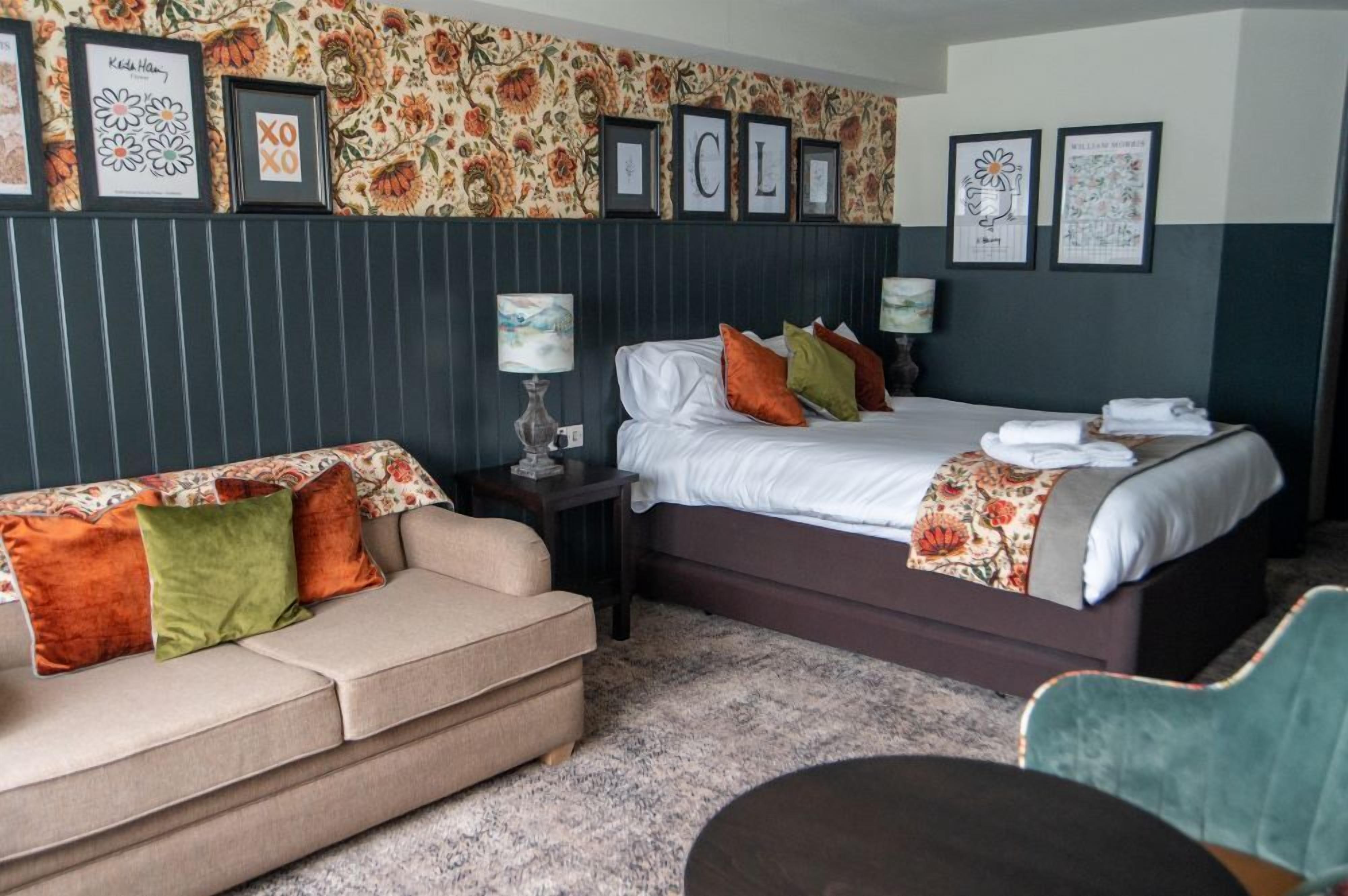 Een hotelkamer met een bed, een bank en een nachtkastje.