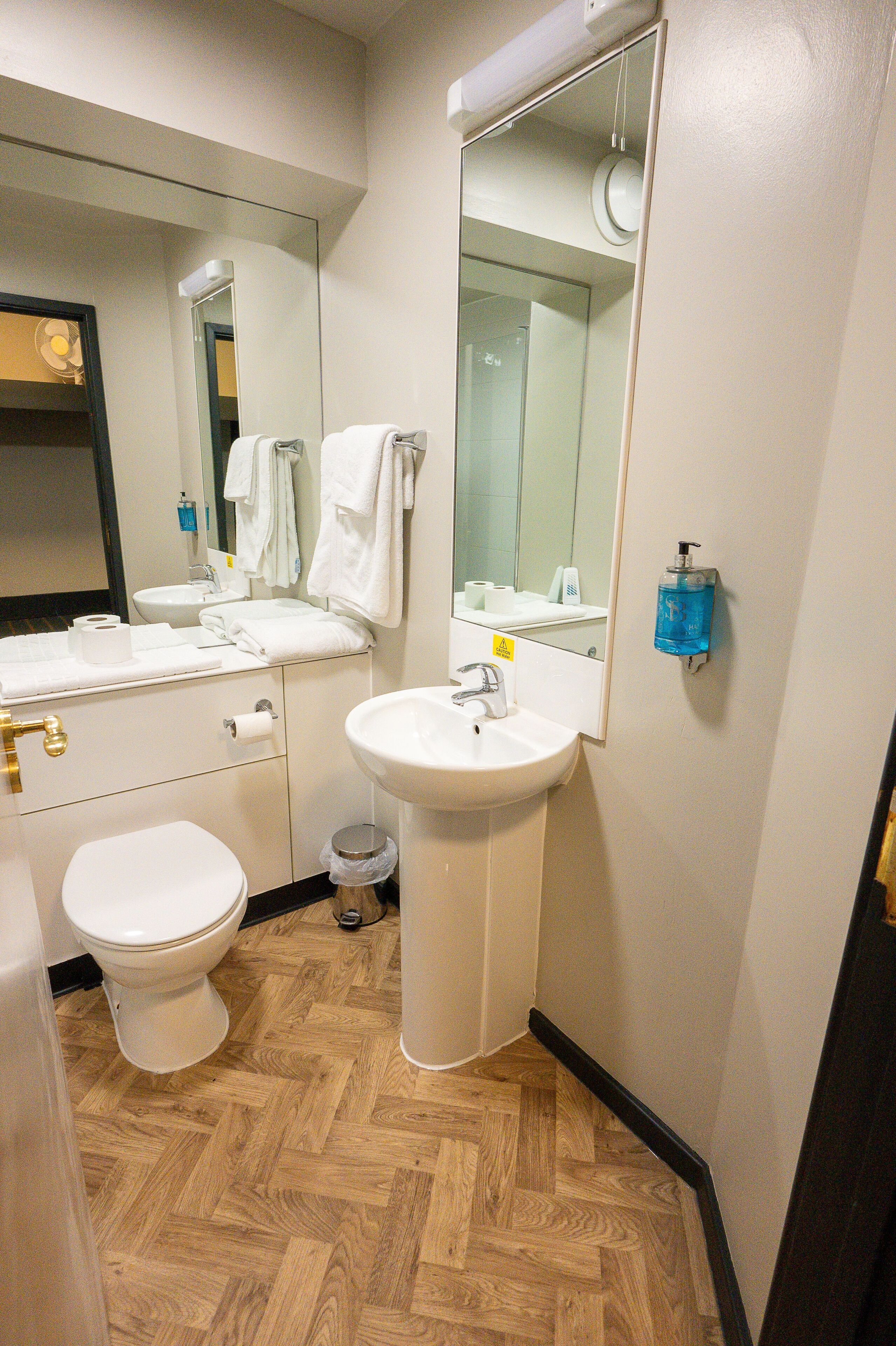 A modern bathroom with a toilet, sink, and mirror.