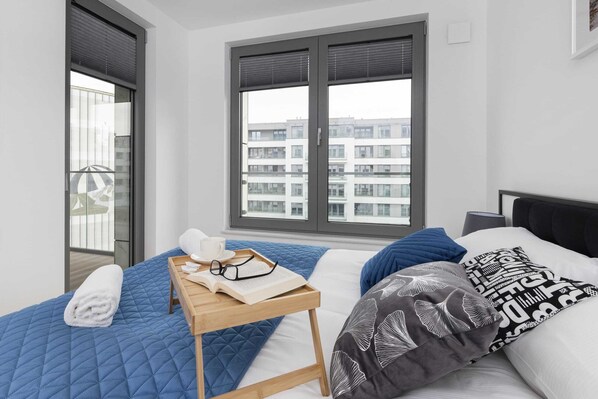 Relax in a serene space with a large bed, a reading nook, and a view of the city.