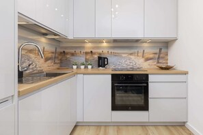 Enjoy cooking in this kitchen with sleek cabinetry, a dishwasher, and a coffee maker.