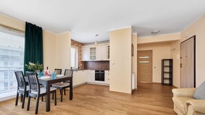 A modern apartment with a dining area, kitchen, and living room. - Spacious Apartment | Balcony, Parking, Workspace (Wroclaw)