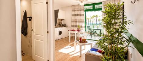 Un espacio habitable compacto con kitchenette, comedor y balcón con vistas.