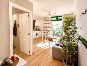 Ein kompakter Wohnraum mit Küchenzeile, Essbereich und Balkon mit Blick.