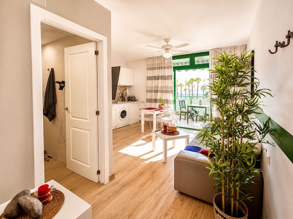 Un espace de vie compact comprenant une kitchenette, un coin repas et un balcon avec vue.