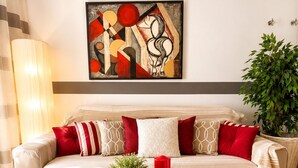Ein modernes Wohnzimmer mit einer Couch, einem Couchtisch und einem Gemälde an der Wand.