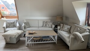 Un salon confortable avec un canapé, une table basse et une lampe.