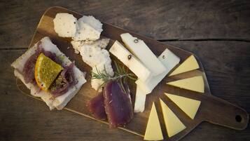 Une planche en bois garnie de différents fromages et de charcuteries.