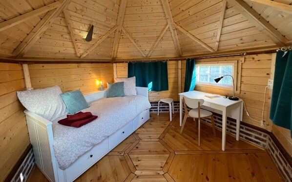 Ein gemütliches Cabin-Zimmer mit einem Bett, einem Schreibtisch und einem Fenster.