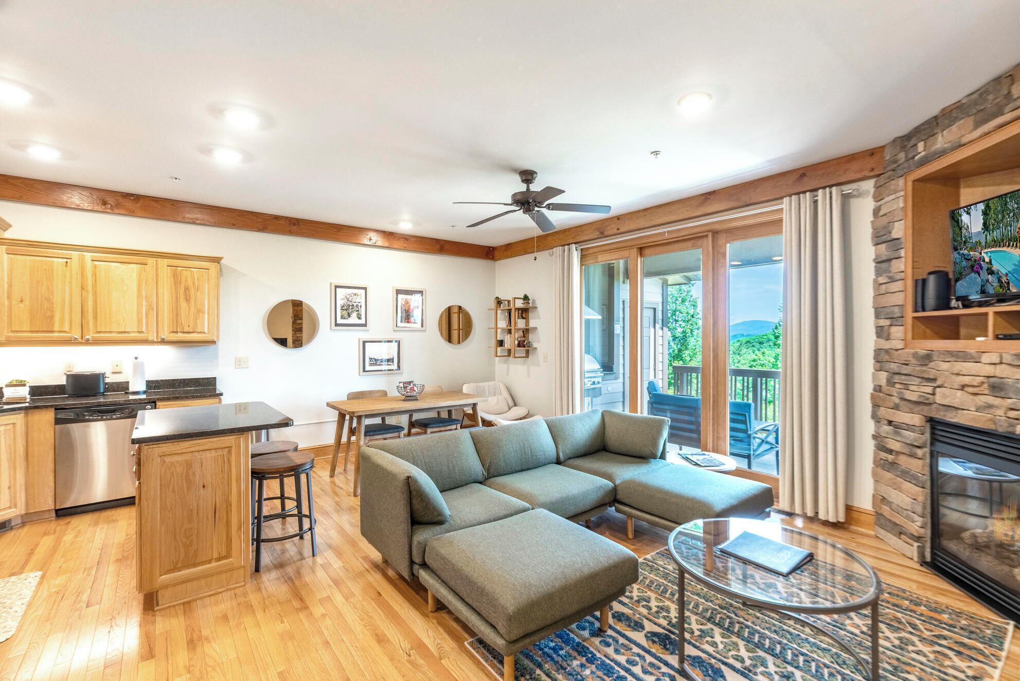 A spacious living area with a sectional sofa, a dining table, and a kitchen with wooden cabinets.