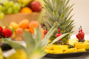 Una bandeja de frutas con piña, fresas y mangos.