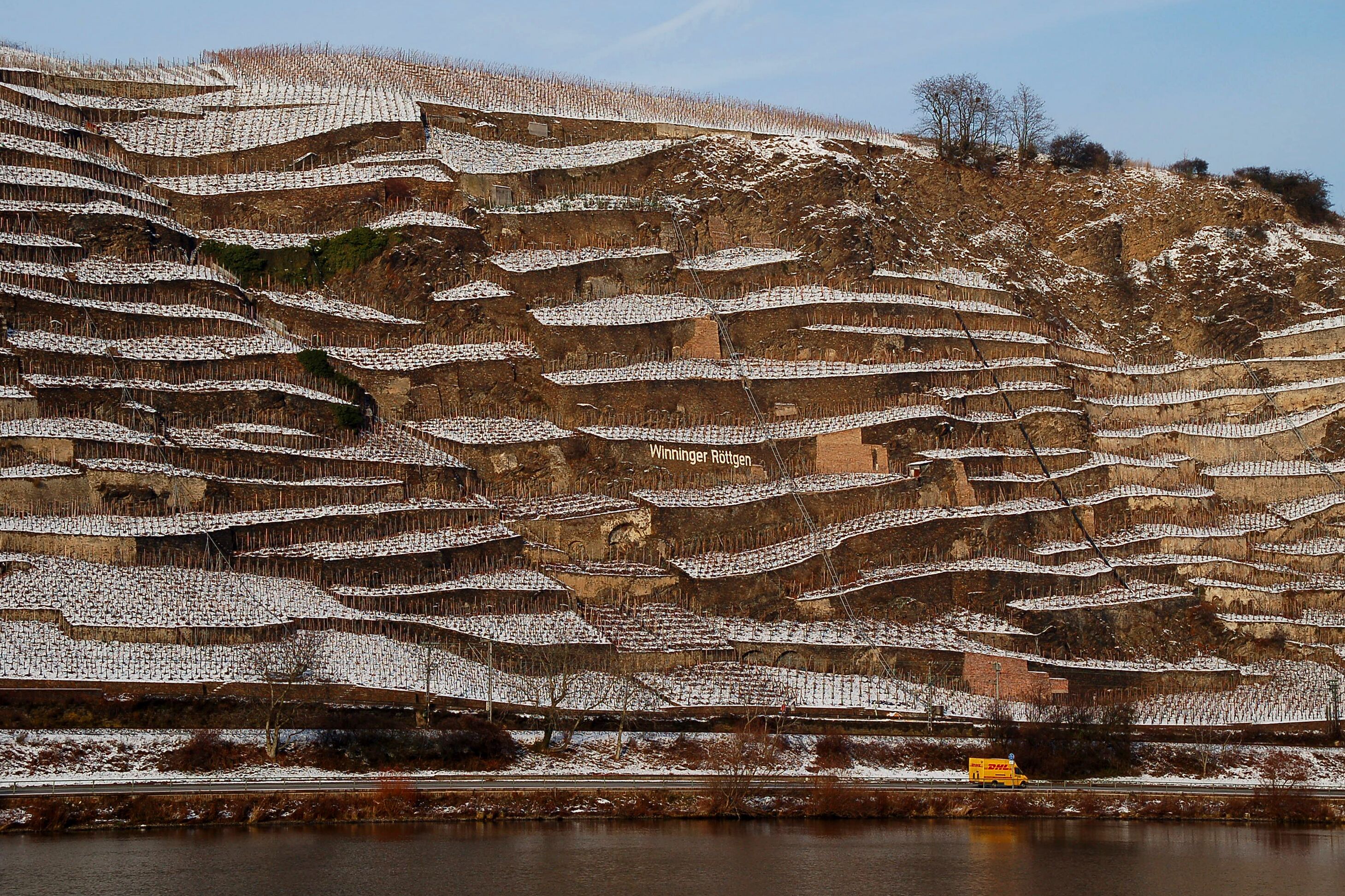 Terraced vineyards with a river in the foreground.